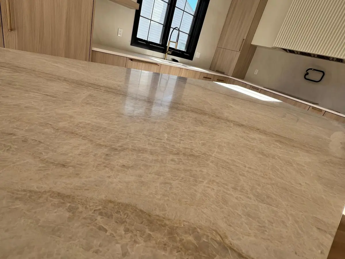 Beige quartzite countertop by black windows